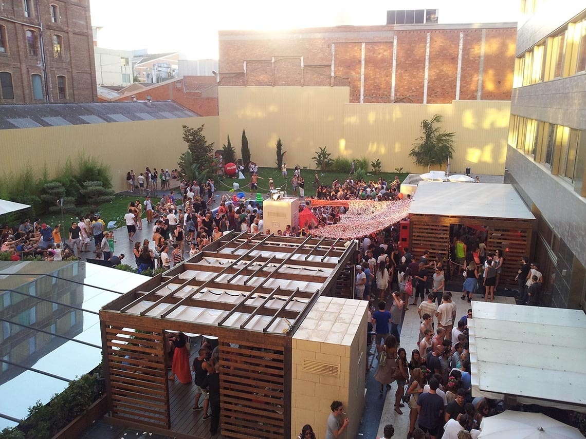 una multitud de personas se reúnen en un patio al aire libre