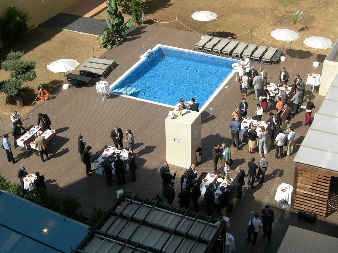 un grupo de personas se reúnen alrededor de una piscina