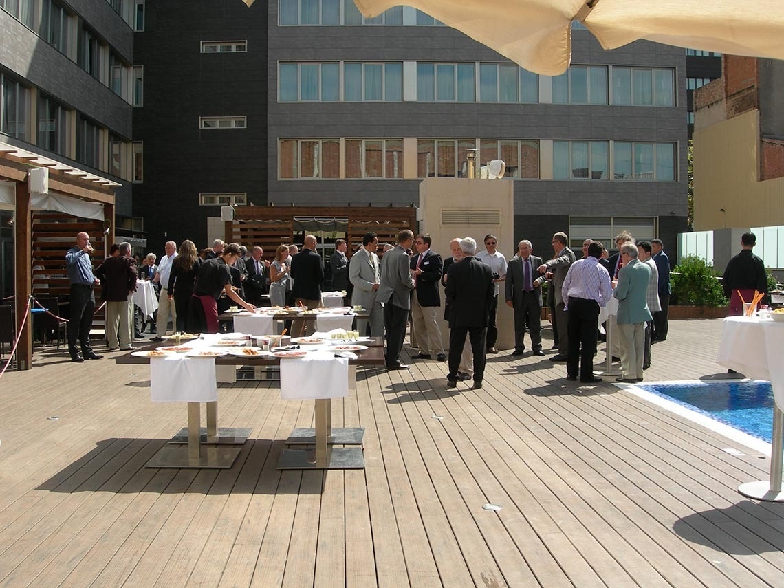 un grupo de hombres de negocios se reúnen en una terraza de madera junto a una piscina