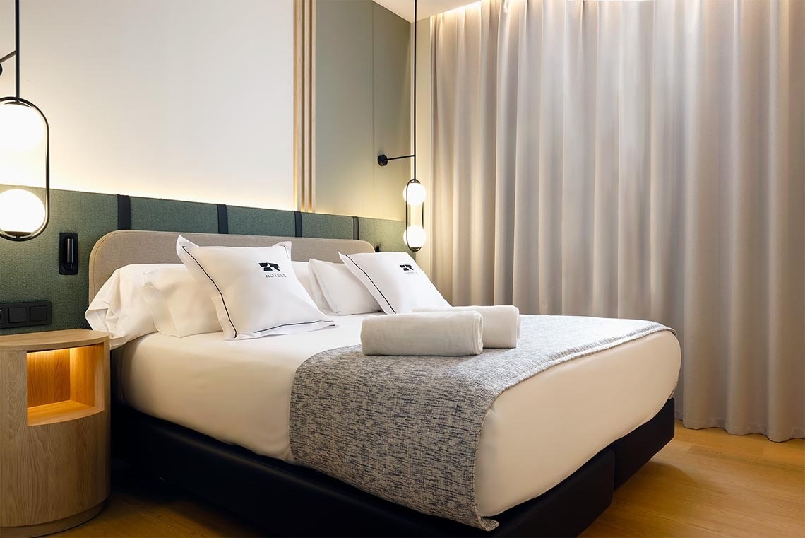 una habitación de hotel con una cama y una mesita de noche