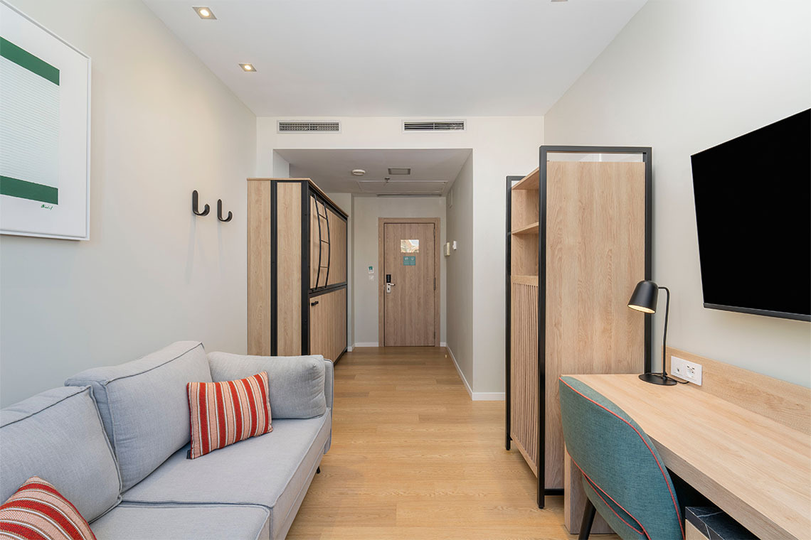 Sofá y armario moderno en habitación de hotel conZT: Villa Olimpica.