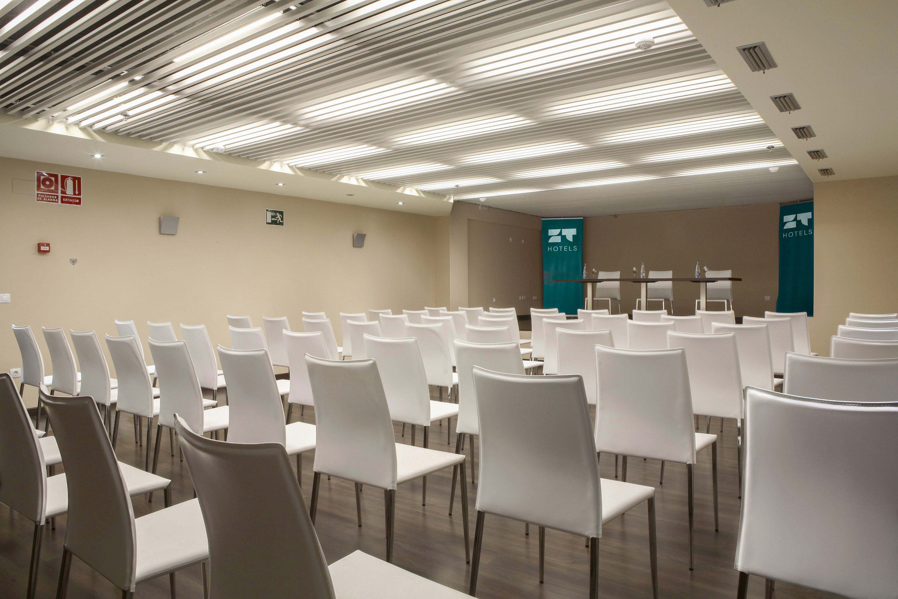 Sala de reuniones moderna con sillas naranjas y vista a ZT: Villa Olimpica.