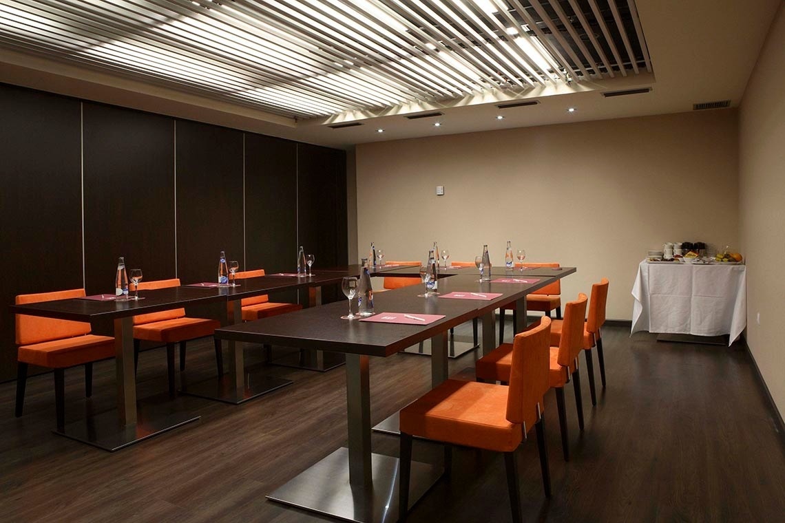 una sala de conferencias con mesas y sillas naranjas