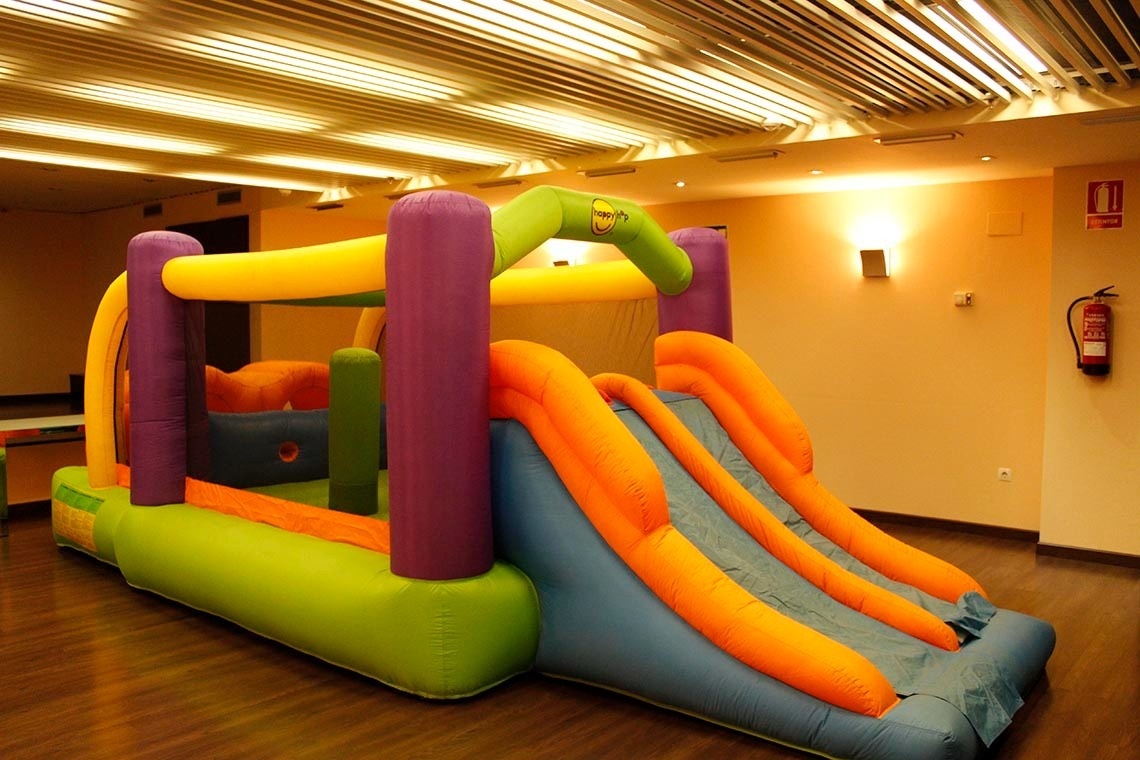 un castillo hinchable con un tobogán en una habitación