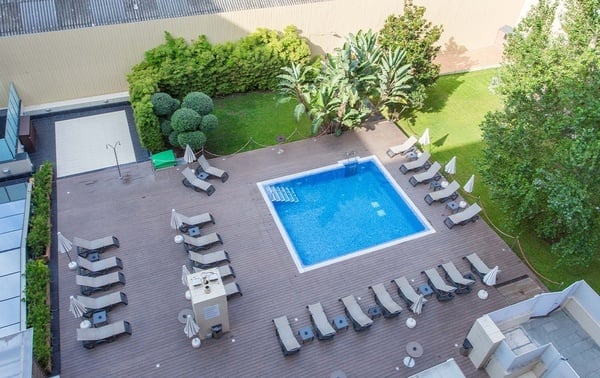 una gran piscina rodeada de edificios y palmeras