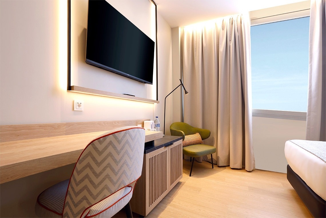 una habitación de hotel con un escritorio y una televisión