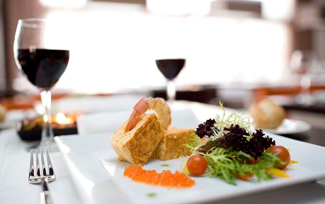 un plato de comida y un vaso de vino en una mesa