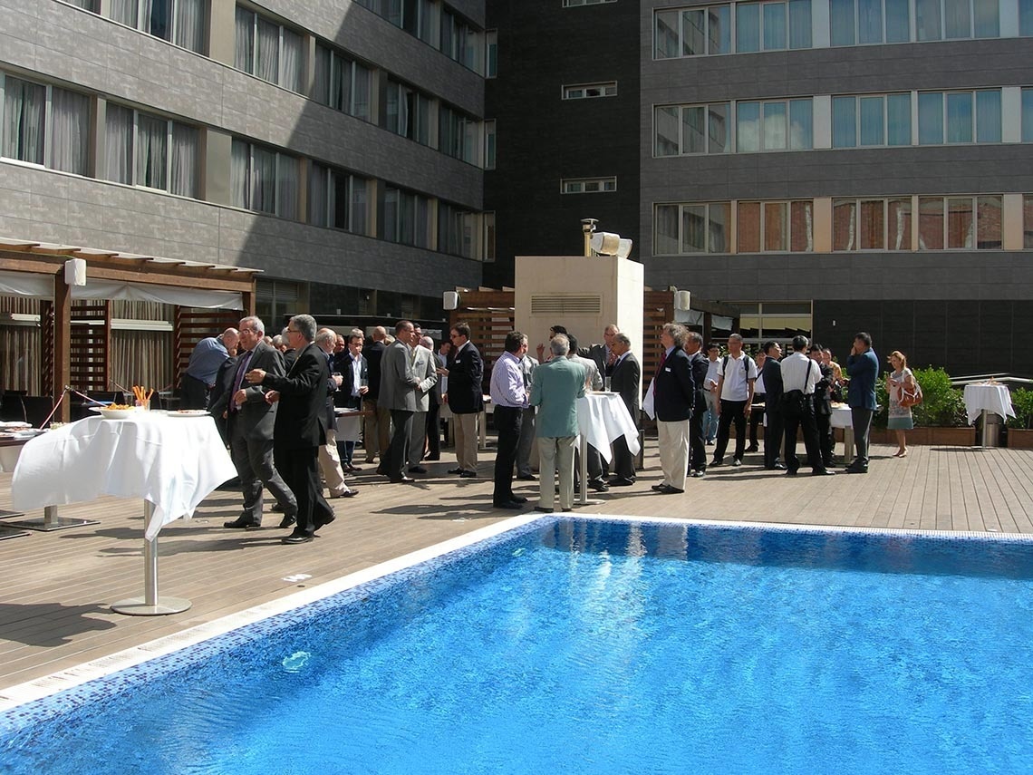 un grupo de personas se reúnen alrededor de una piscina