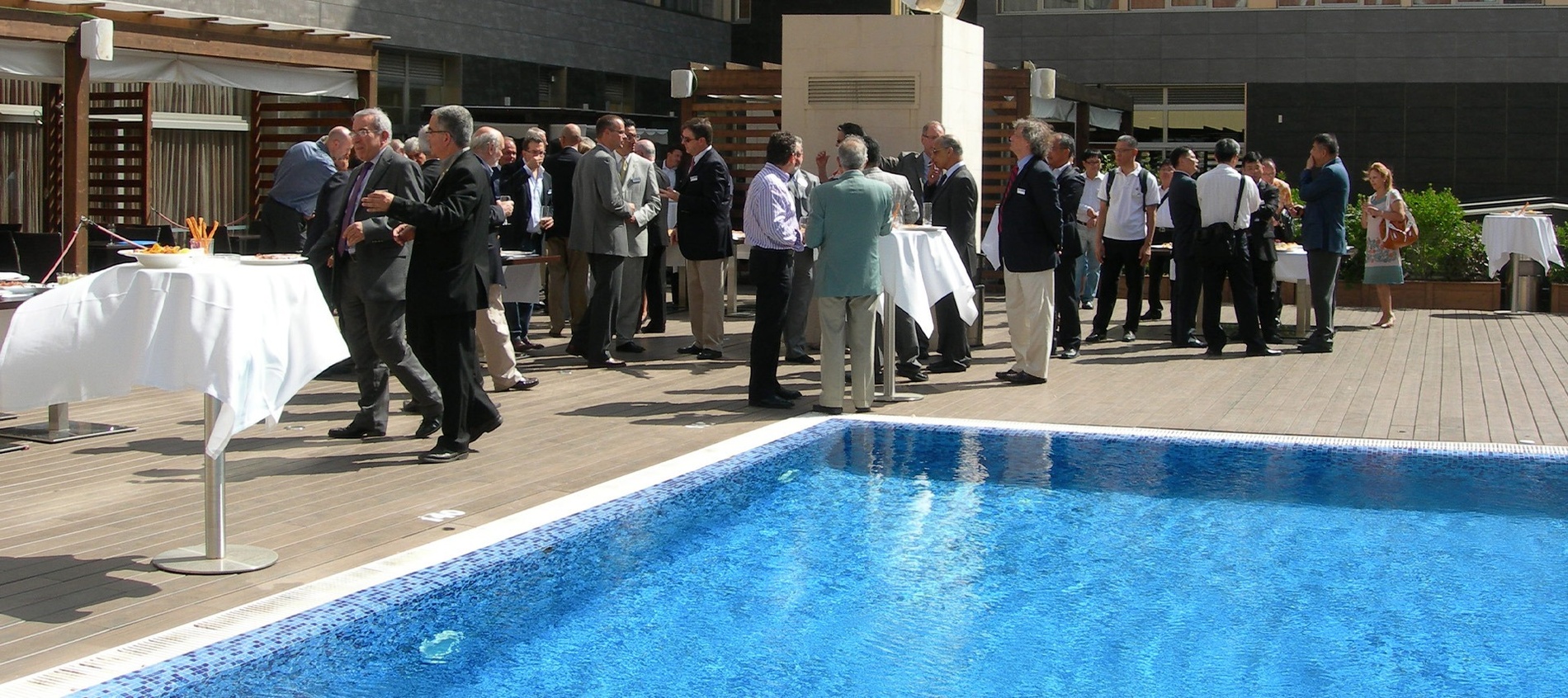 un grupo de personas se para alrededor de una piscina