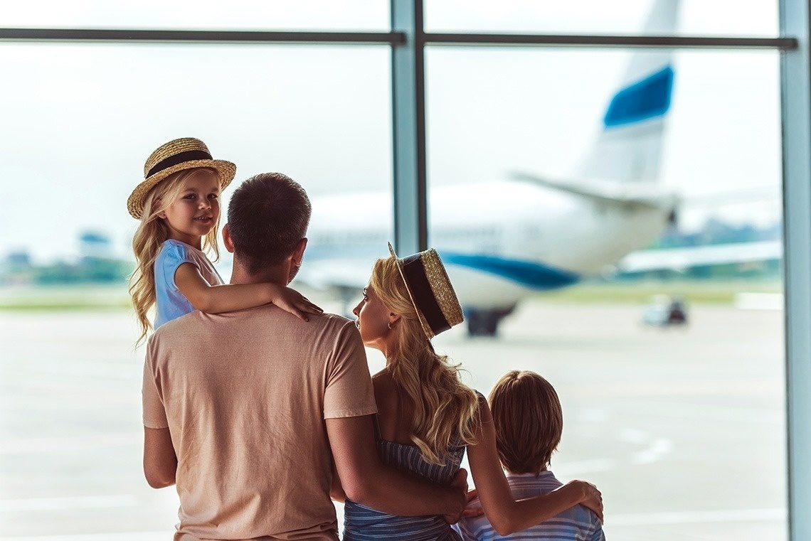 una familia mira un avión en el aeropuerto