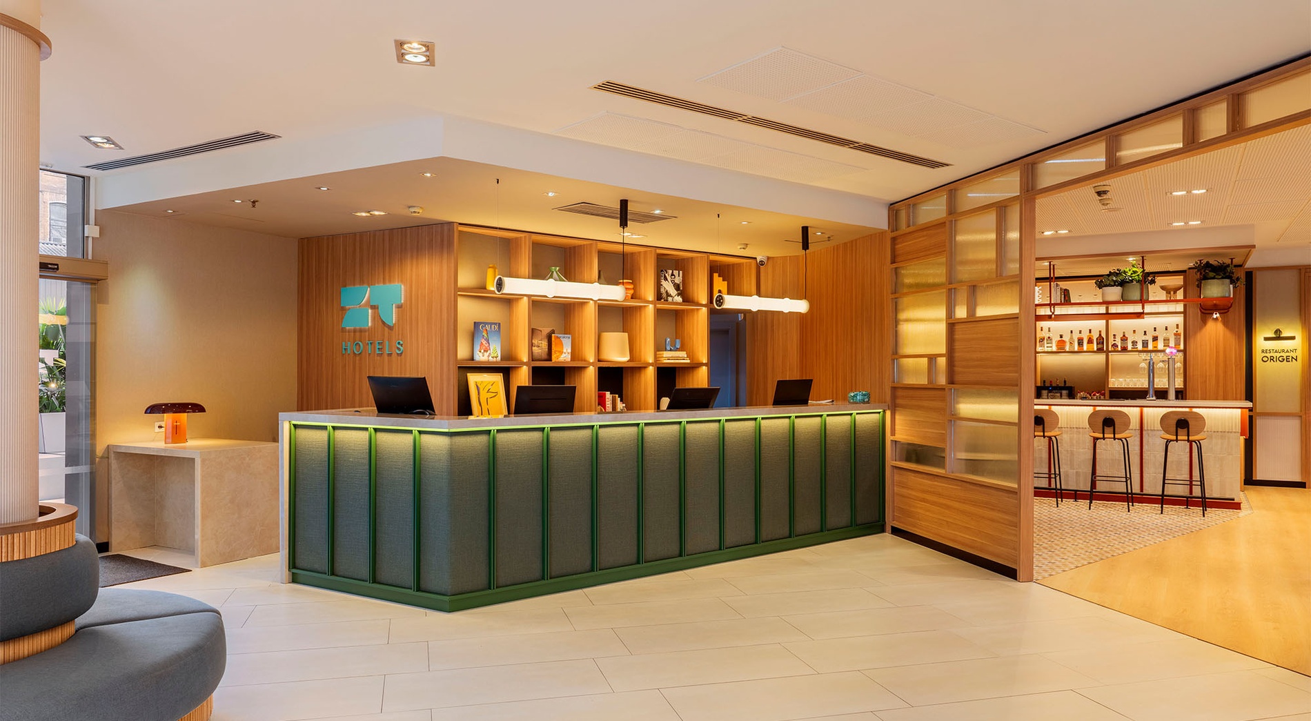 Habitación de hotel moderna con TV, escritorio y sofá. Preguntas Frecuentes | ZT Hotel & Spa Villa Olímpica Suites.