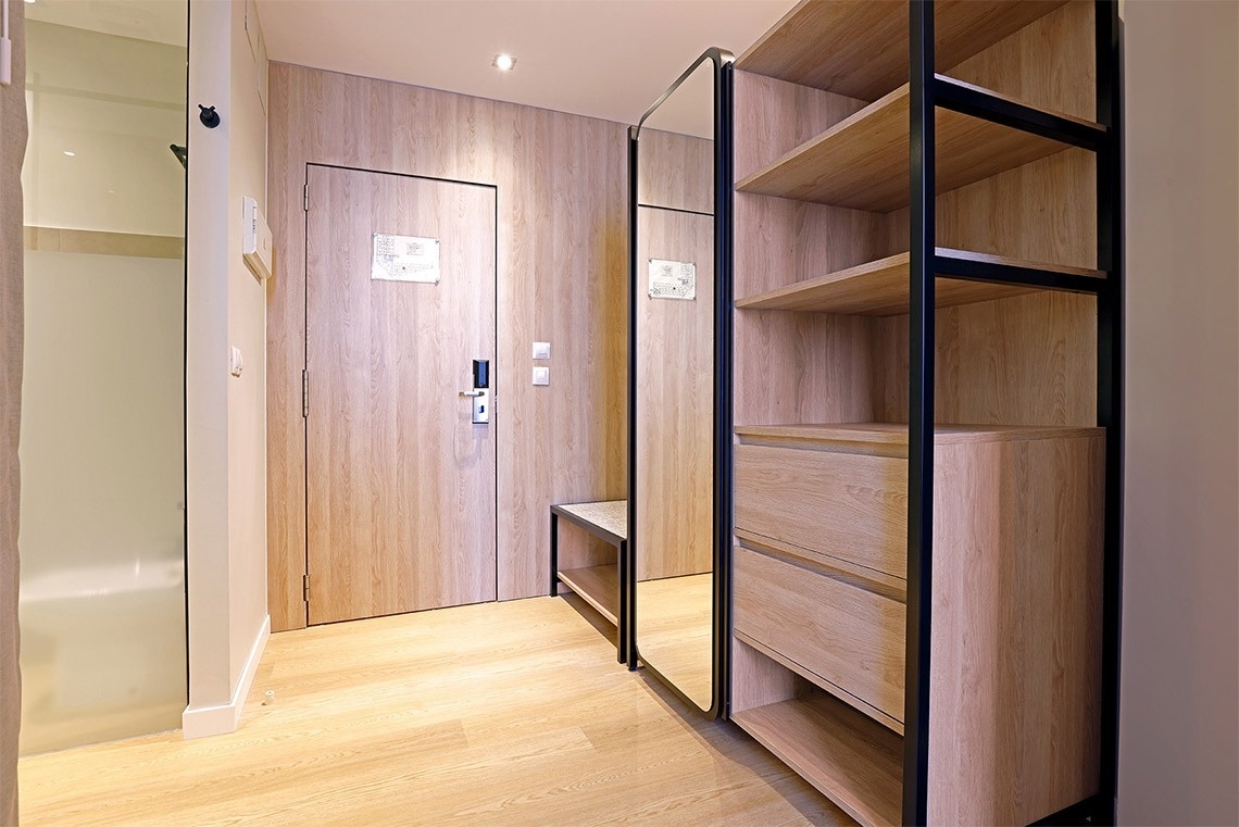 un pasillo con una puerta de madera y un espejo