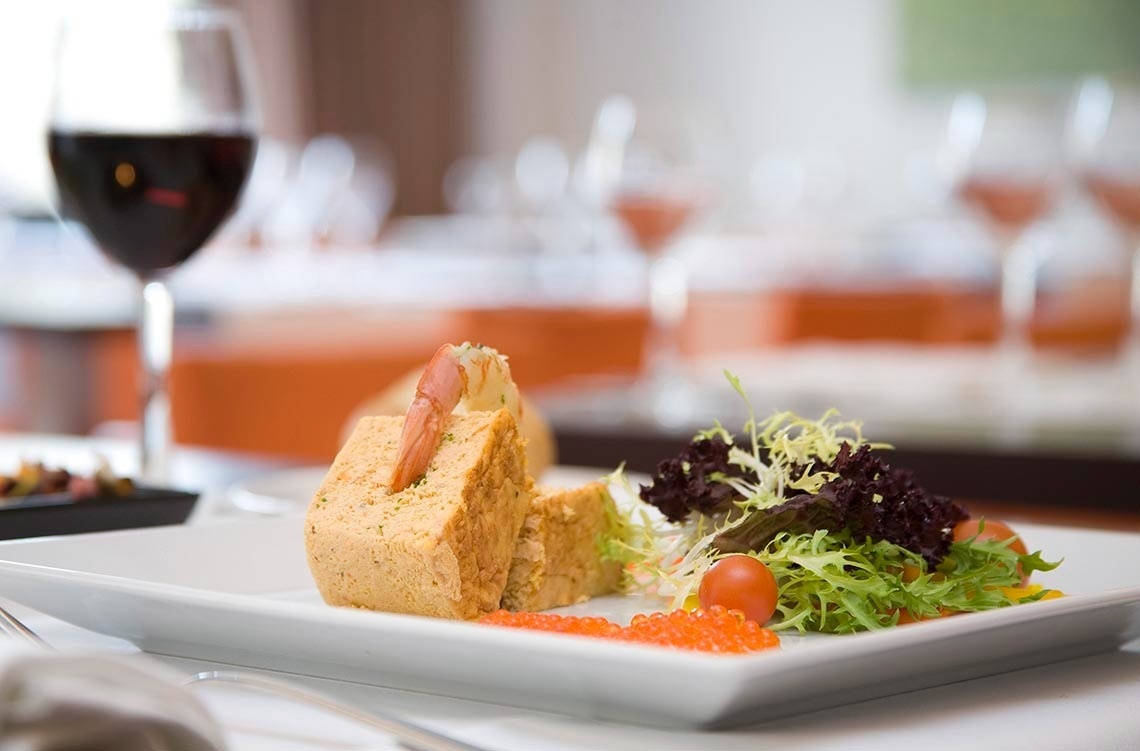 un plato de comida y una copa de vino en una mesa